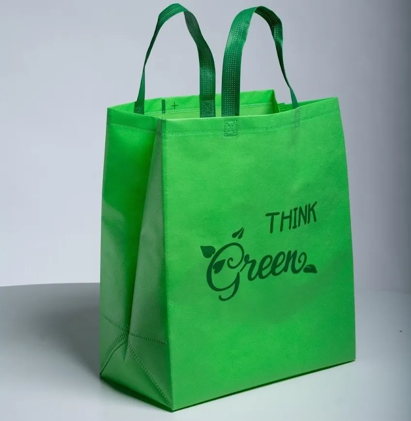 A green reusable bag with bold lettering encouraging green thinking, designed for sustainable shopping.